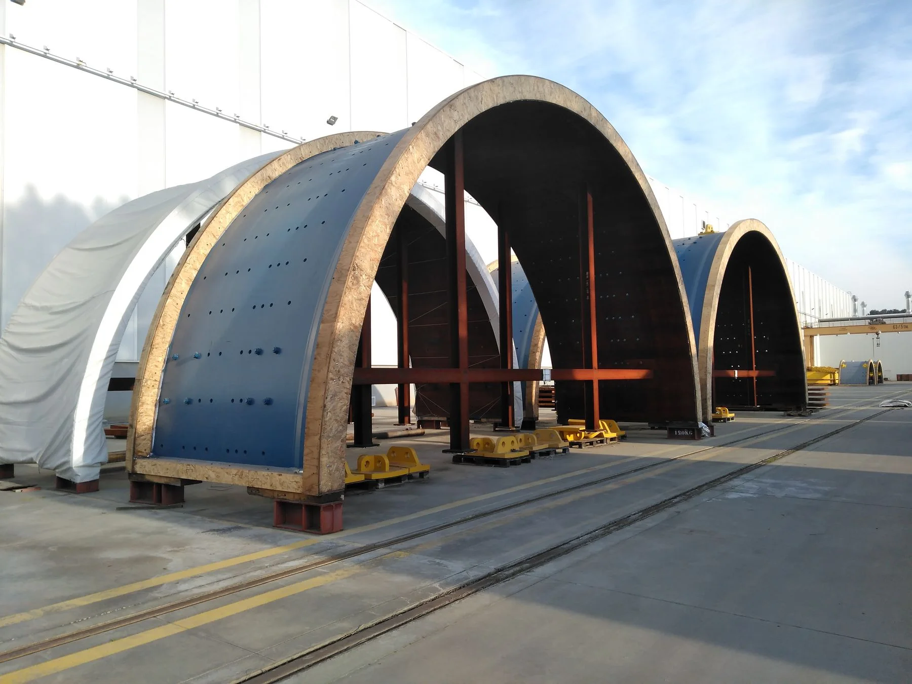 Grinding mill shell sections in timber shipping cradles, drilled for liner bolts